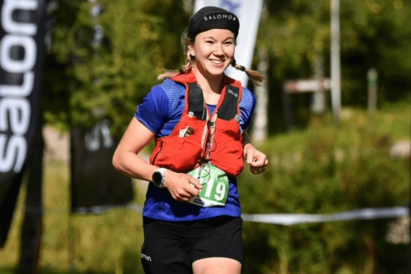 Kuvassa on Anna-Stiina Erkkilä, joka hymyilee juostessaan.
